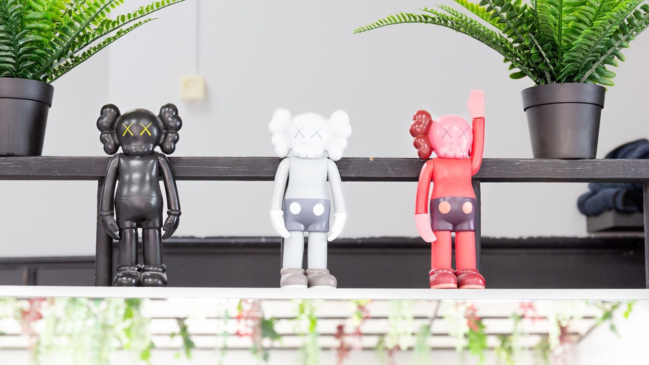 Plank met drie designfiguren tussen de planten
