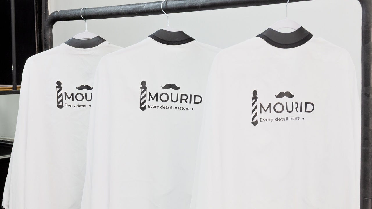 Drie witte kappers-capes met het Mourid-logo en Every detail matters