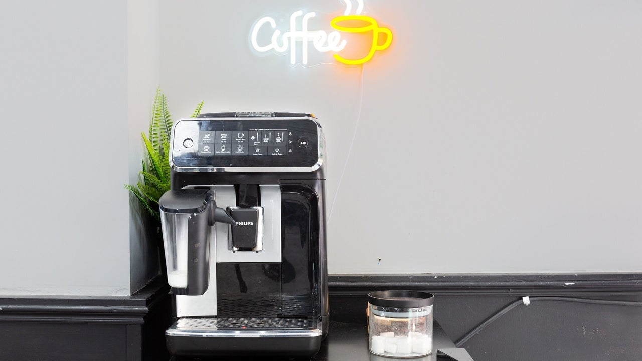 Espressomachine onder een neonbord met het woord Coffee