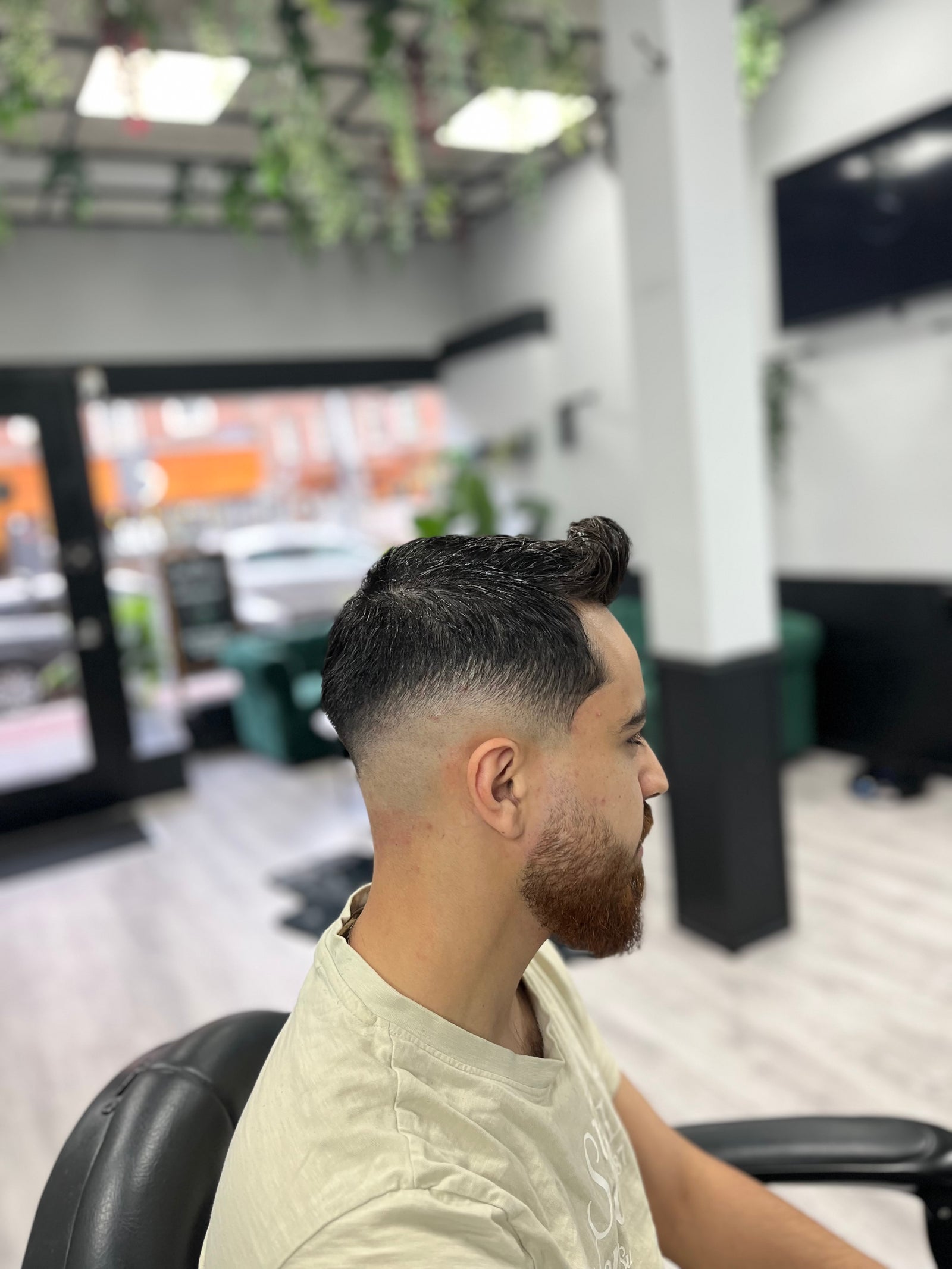 Fade met getrimde baard, van opzij, in de zaak