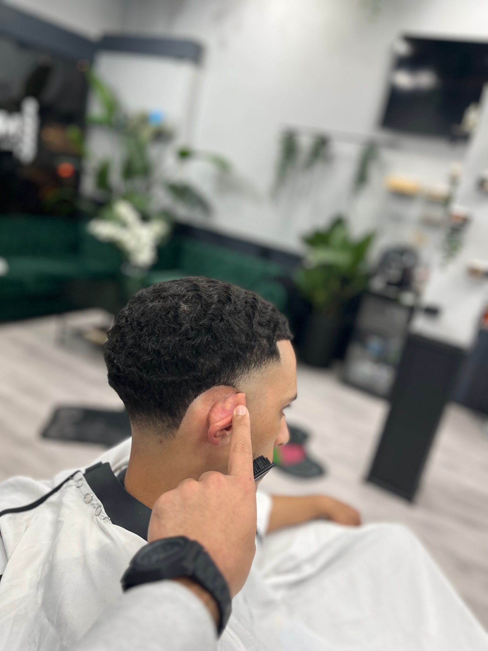 Krullen met een strakke fade in de nek, van achteren gezien